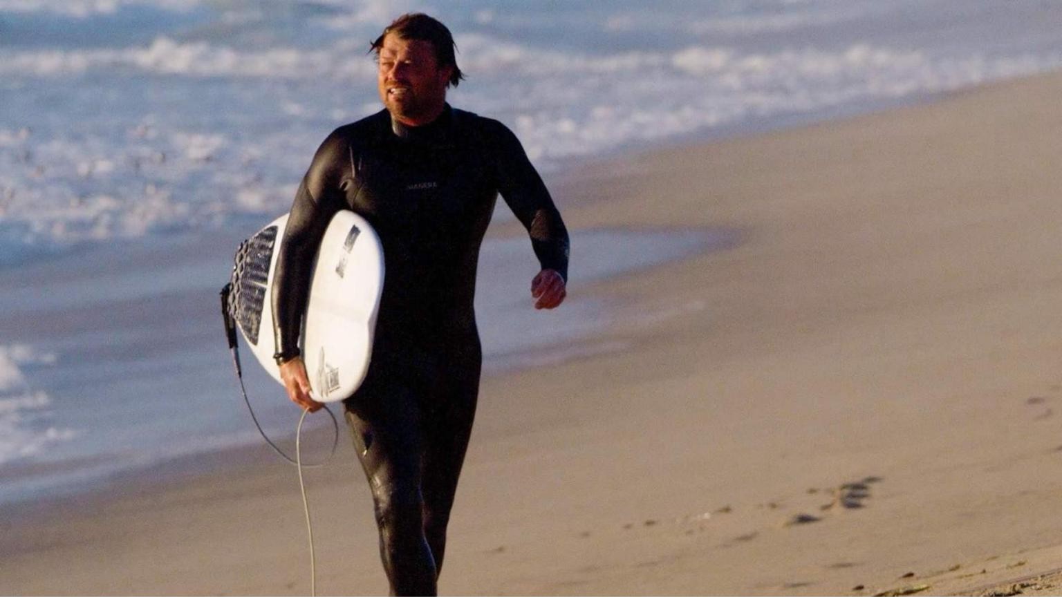 Surfeur en combinaison Manera sur la plage